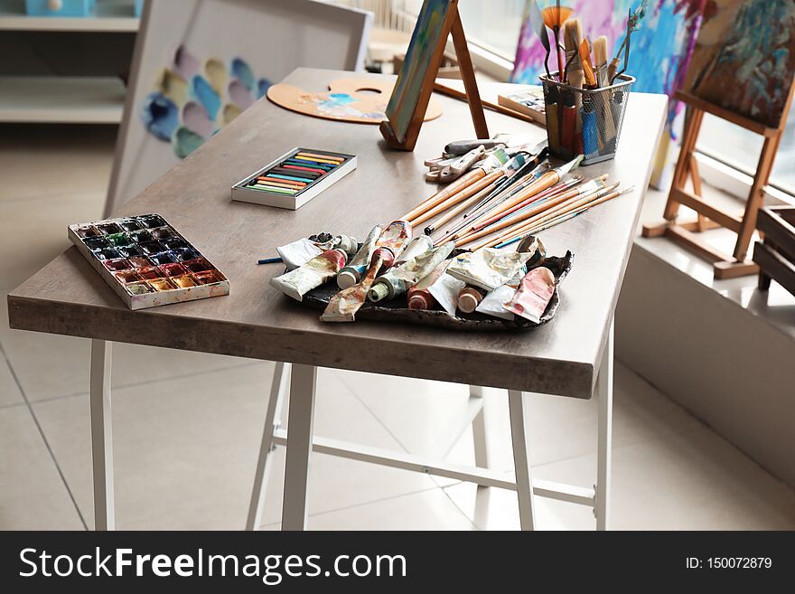 Table With Tools And Paints In Artist S Workshop