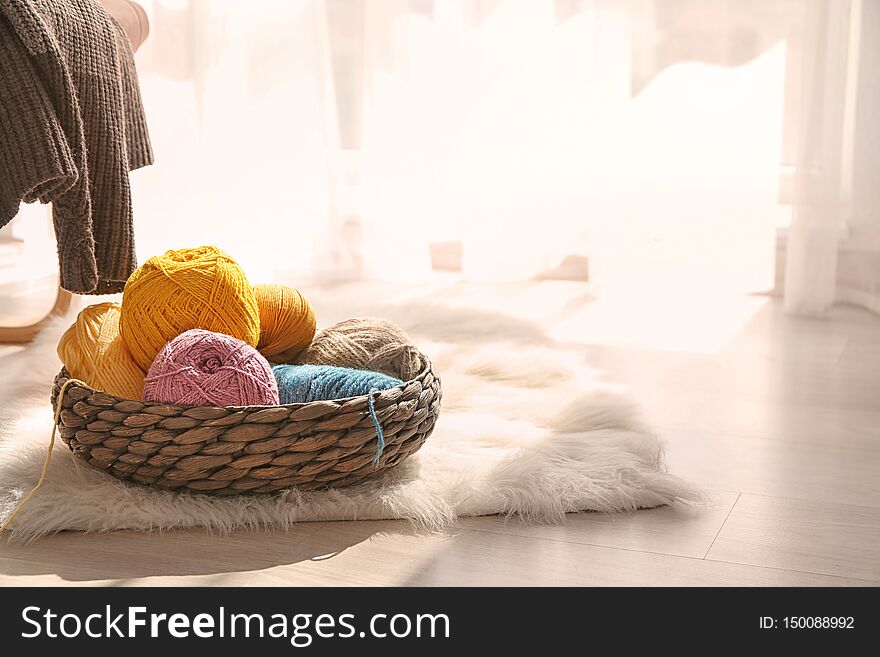 Wicker basket with knitting yarn on furry rug