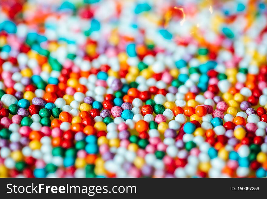 Multicolored sweet candy for sprinkling confectionery, ice cream and donuts. Edible children`s toys and cookies in the form of dots. Background image, wallpaper. Multicolored sweet candy for sprinkling confectionery, ice cream and donuts. Edible children`s toys and cookies in the form of dots. Background image, wallpaper
