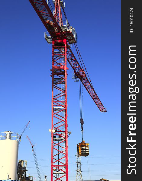 A heavy duty crane moving objects around an industrial workplace. A heavy duty crane moving objects around an industrial workplace.