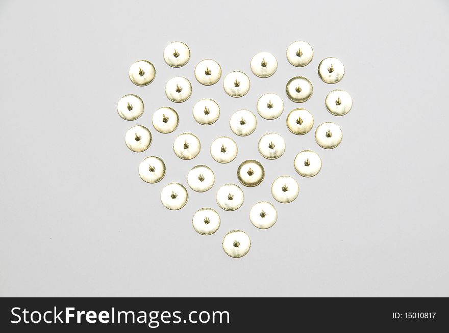 The golden thumbtack arranged love heart shape