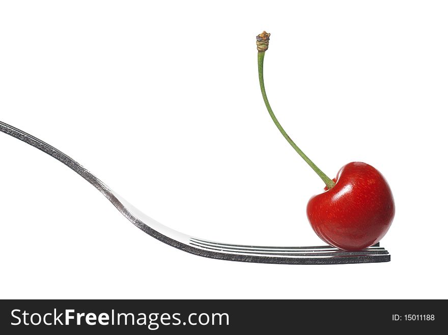 Red cherry on fork isolated on white background