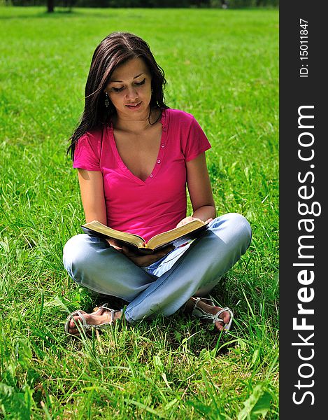 Woman with a book sitting on the grass