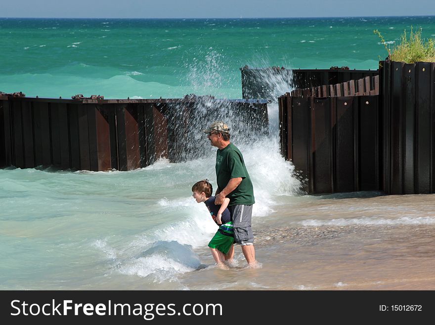 A young boy and his grandfather are standing near the shore and waves of lake Michigan. Taken at the breakwall at Point Betsie beach. A young boy and his grandfather are standing near the shore and waves of lake Michigan. Taken at the breakwall at Point Betsie beach.