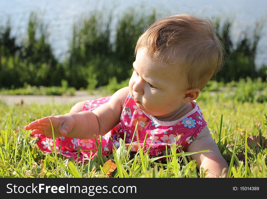 The girl lays on a grass near lake. The girl lays on a grass near lake