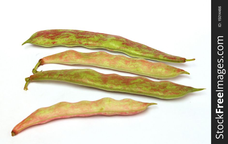 Four red-green pod color beans separately lie on a white background. Four red-green pod color beans separately lie on a white background