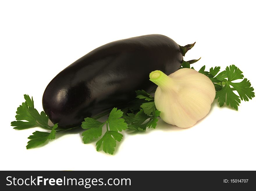 One dark blue eggplant, one pink and white garlic, several sprigs of parsley on a white background, fresh uncut vegetables. One dark blue eggplant, one pink and white garlic, several sprigs of parsley on a white background, fresh uncut vegetables