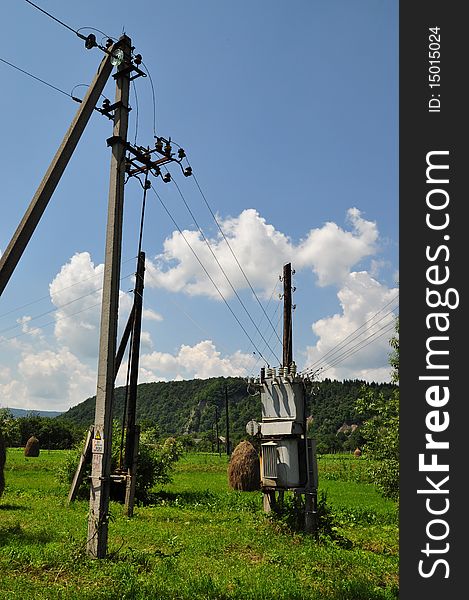 Elements of rural electrosupply in a summer landscape with the dark blue sky. Elements of rural electrosupply in a summer landscape with the dark blue sky.
