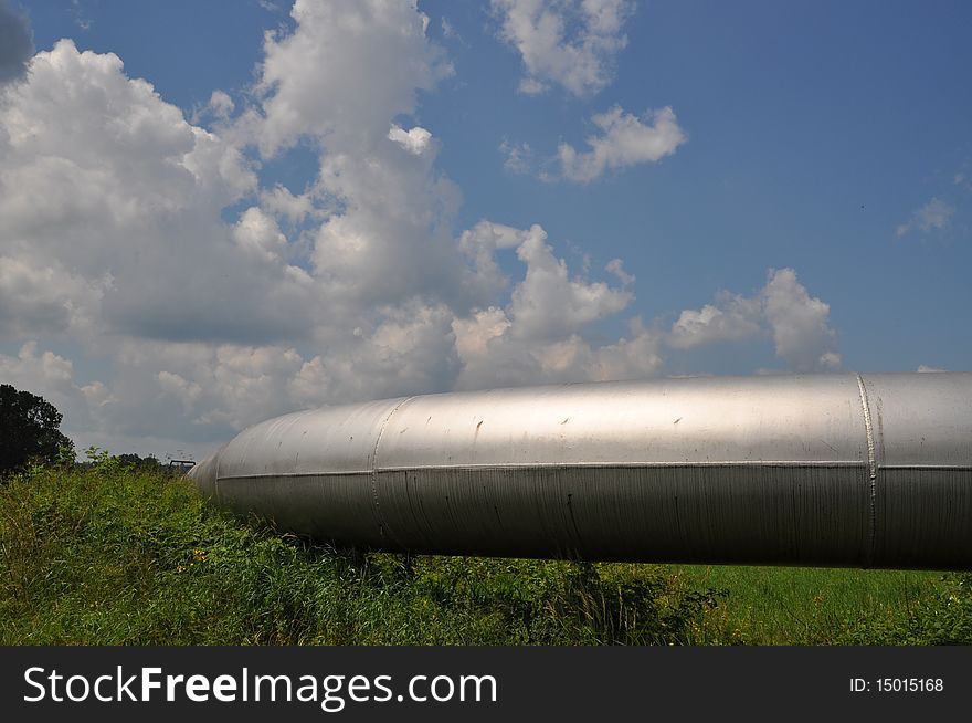 The main gas pipeline of a high pressure in a summer landscape under clouds. The main gas pipeline of a high pressure in a summer landscape under clouds.