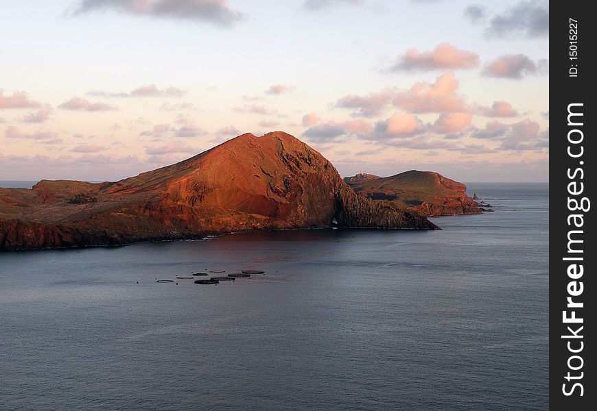 Mountain range in sea with sunset above. Mountain range in sea with sunset above