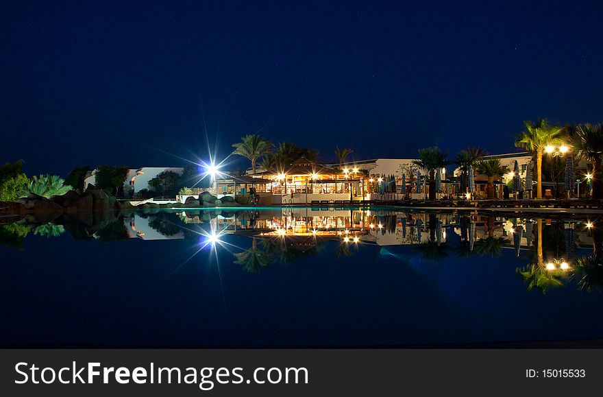 Tropical Resort Reflected In A Pool At Night