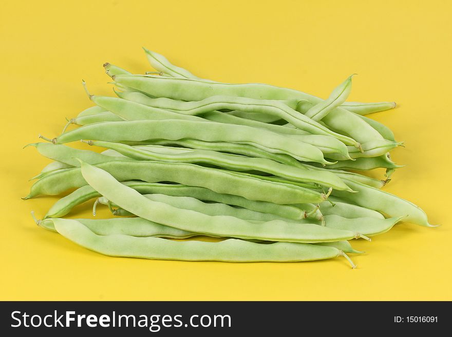 Green beans on yellow background