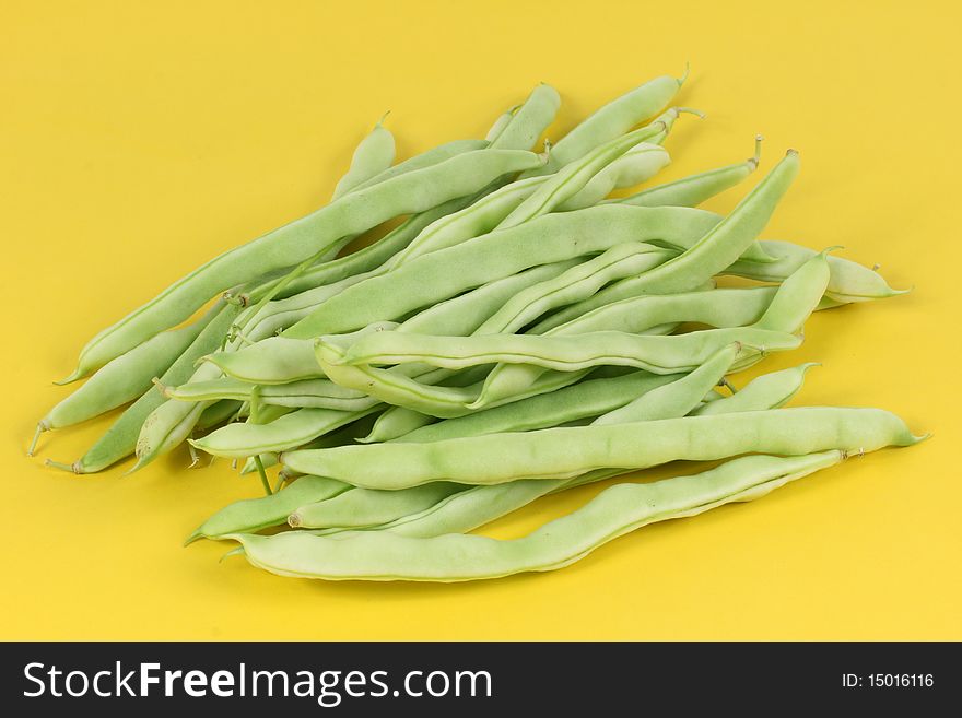 Green beans on yellow background