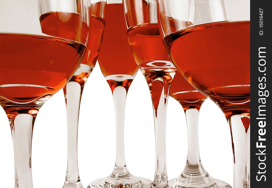 Wine glasses on a white background filled with various levels of a red wine. Wine glasses on a white background filled with various levels of a red wine