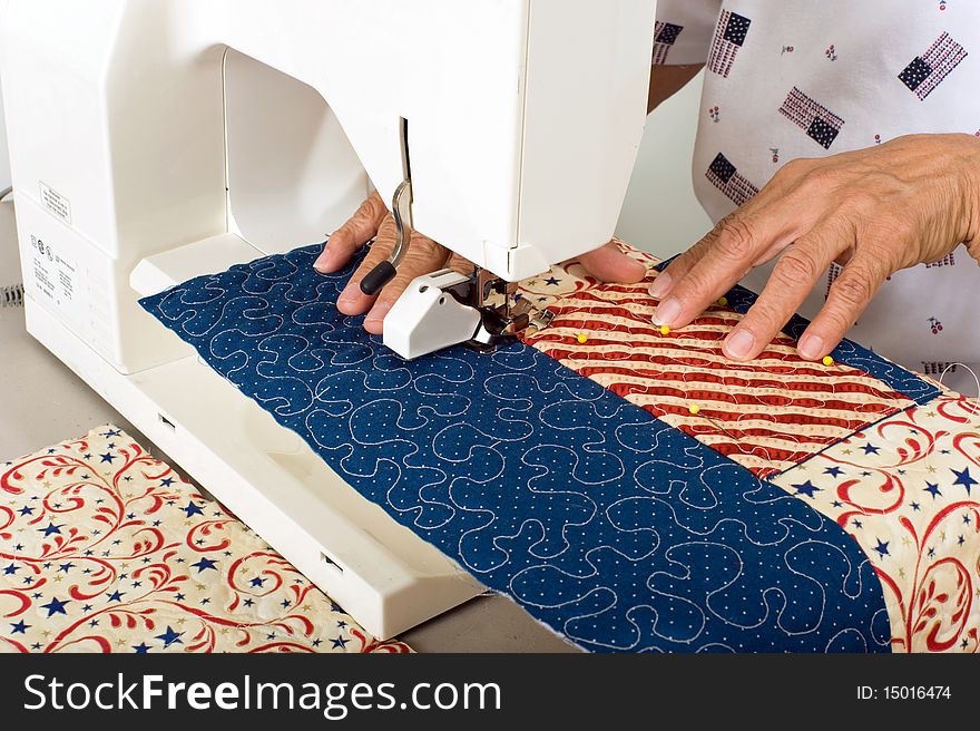 A woman sewing a pocket on front panel of tote bag. A woman sewing a pocket on front panel of tote bag.