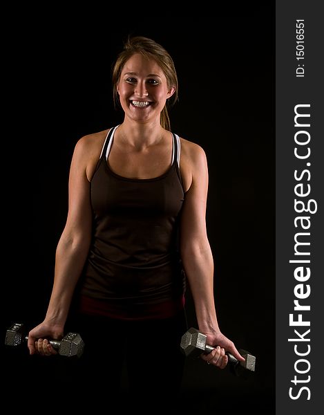 Attractive young woman smiling and curling weights. Attractive young woman smiling and curling weights