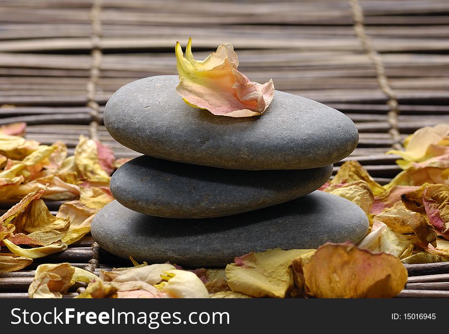 Stack of stone with rose withered petals