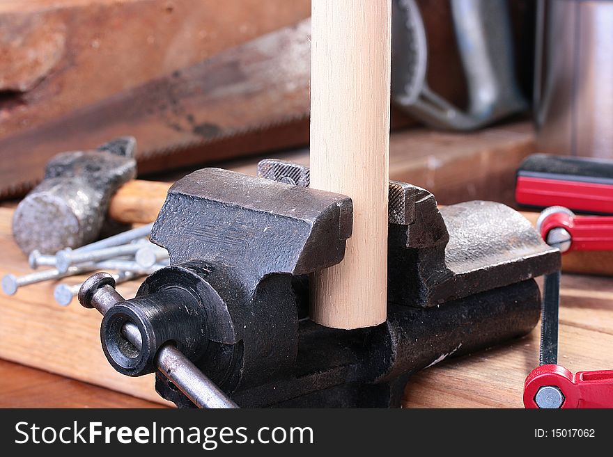 Metalwork vice with the wooden round cylinder.