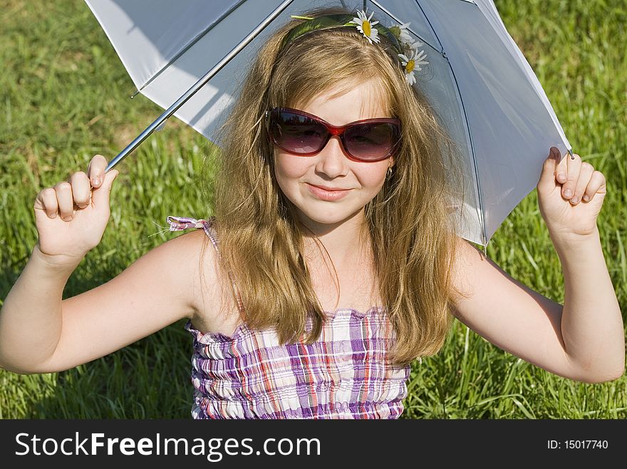 The girl sits on a green lawn. The girl sits on a green lawn