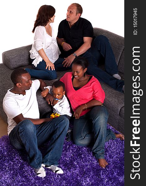 Young group of multiracial friends - two young families enjoying an afternoon at home. Young group of multiracial friends - two young families enjoying an afternoon at home.