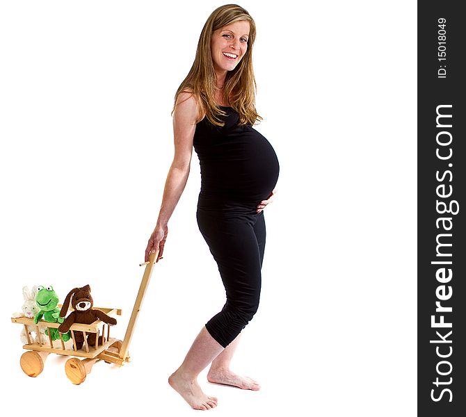 Young fresh pregnant woman is pulling a trolley filled with toy animals isolated over white background. Young fresh pregnant woman is pulling a trolley filled with toy animals isolated over white background.