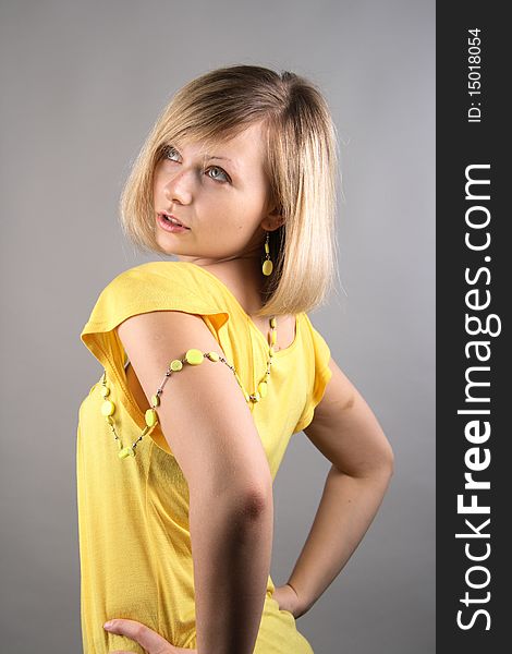 Smiling girl in yellow shirt in studio