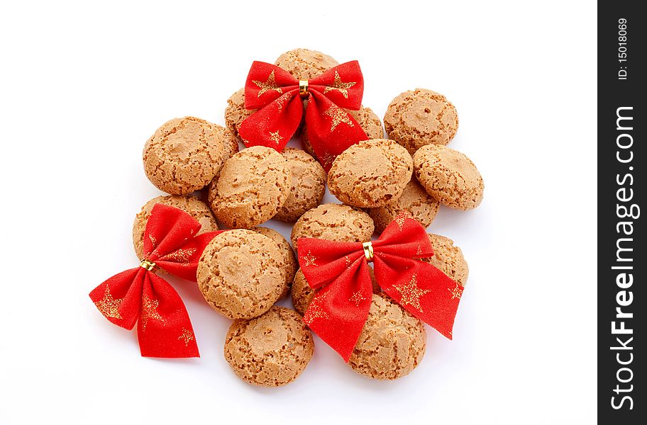 Almond cookies decorated with red velvet bows on white background. Almond cookies decorated with red velvet bows on white background