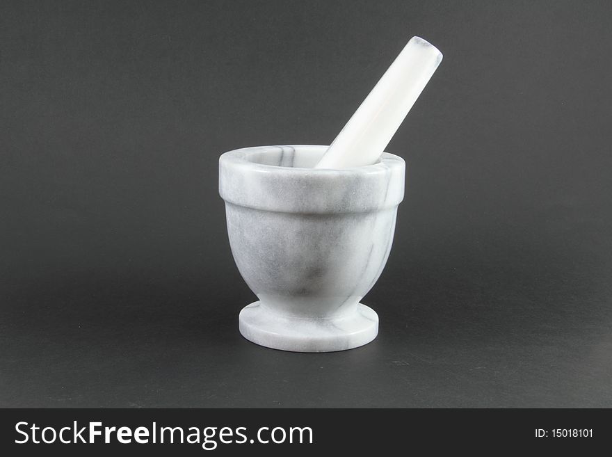 A pharmacist mortar and pestle on a grey background. A pharmacist mortar and pestle on a grey background.