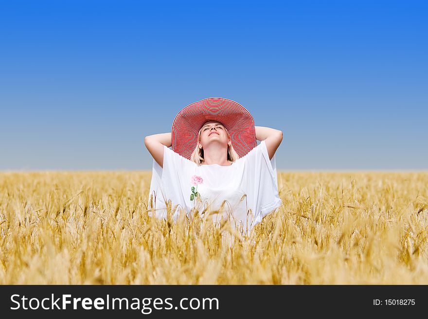 Beautiful woman with hat in wheat meadow on sunny day