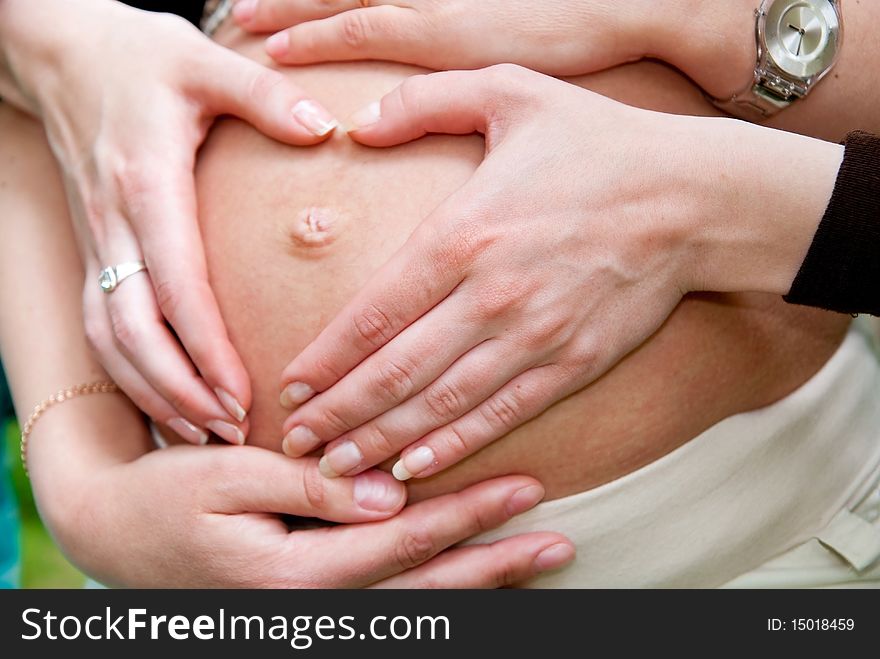 Heart shape made from hands on pregnant woman stomach. Heart shape made from hands on pregnant woman stomach