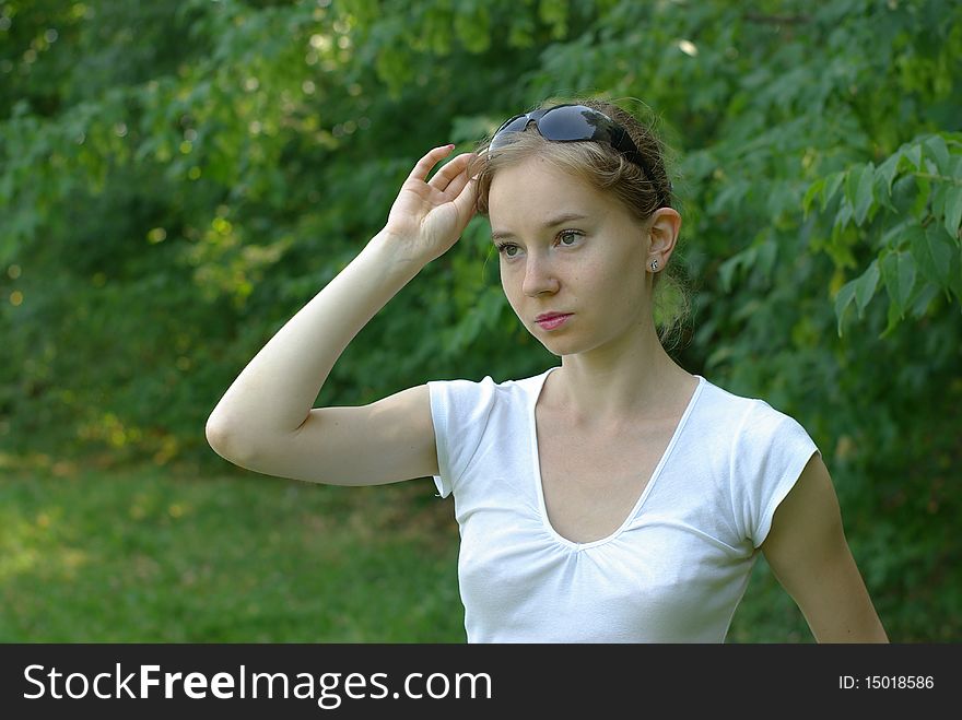 Girl in a white t-shirt holding sunglasses. Girl in a white t-shirt holding sunglasses