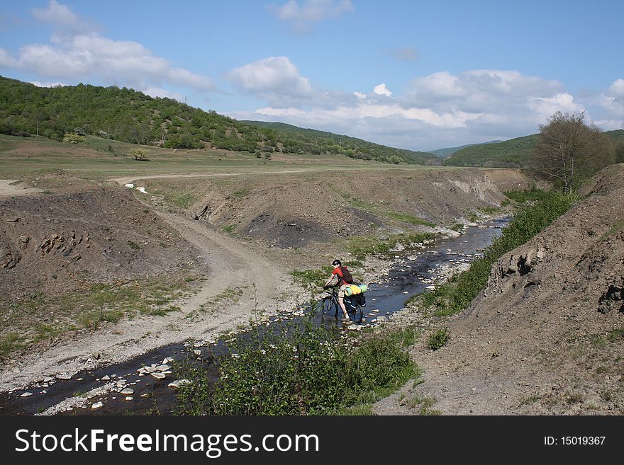 Mountain biker crossing river over the ford