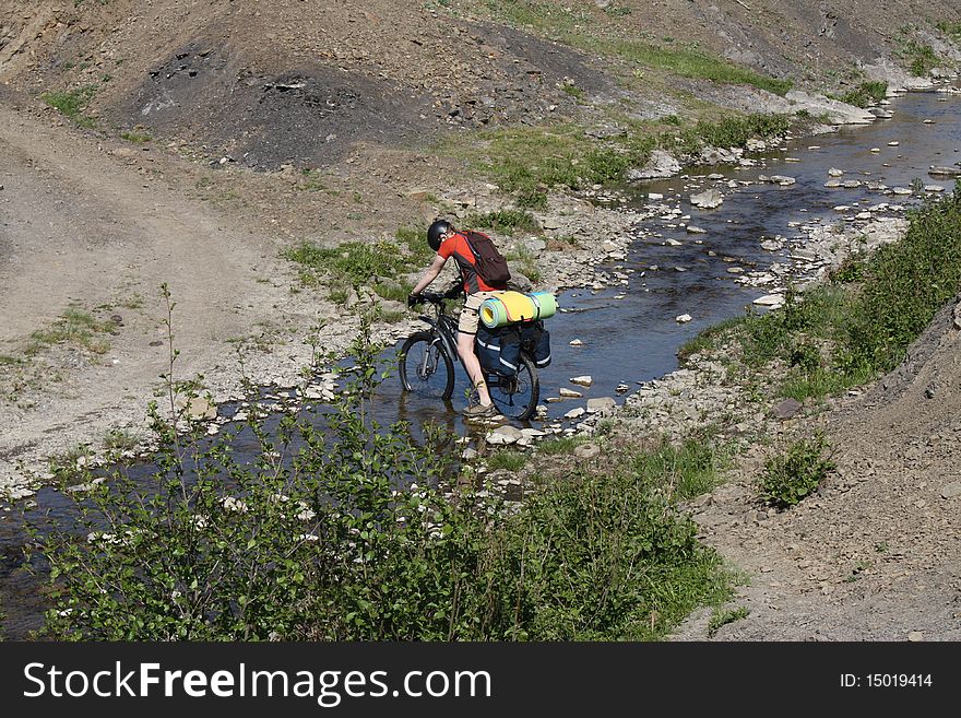 Mountain Biker Crossing River