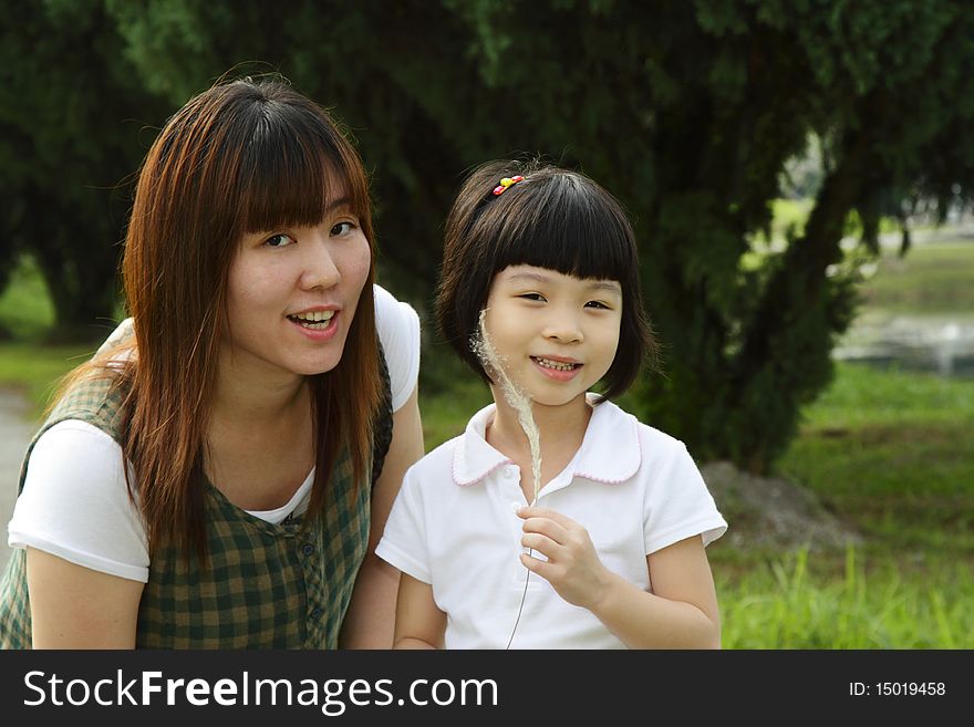 An Asian mother and her daughter at a park. An Asian mother and her daughter at a park