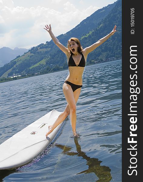 Shot of girl at her first surfing attempt at austrian lake