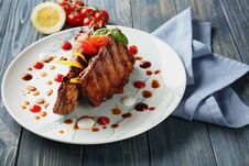 Plate With Delicious Grilled Ribs And Sauces On Table Royalty Free Stock Photos