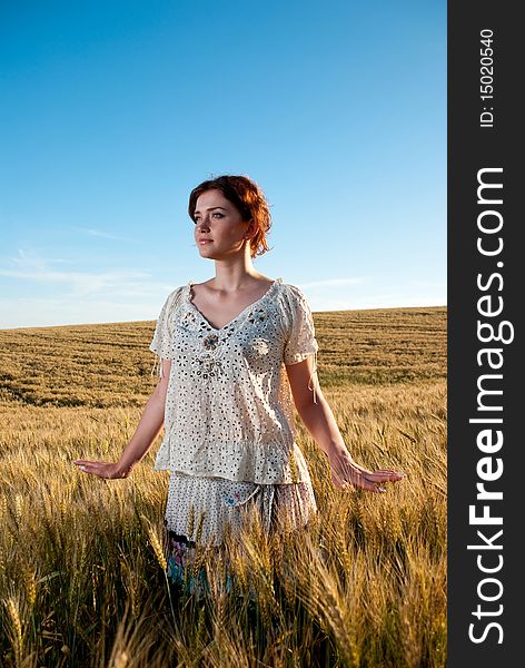 Young redhead woman at wheat field. Young redhead woman at wheat field