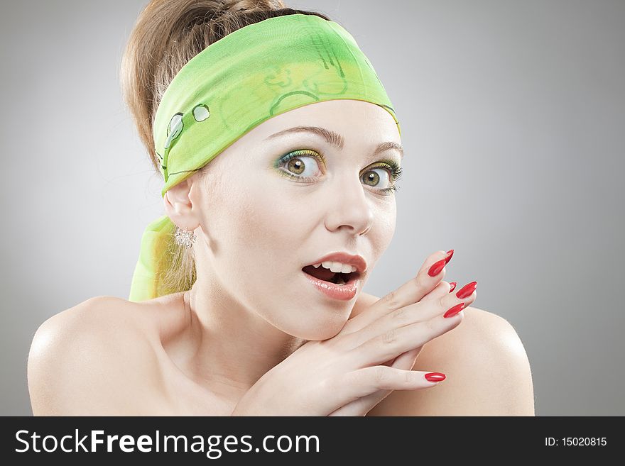 Closeup portrait of surprised woman with beautiful green eyes and green bandage on head