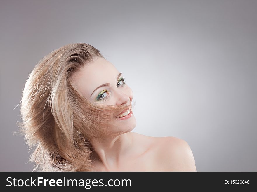 Portrait of a happy smiling woman with her beautiful blowing hair mid movement