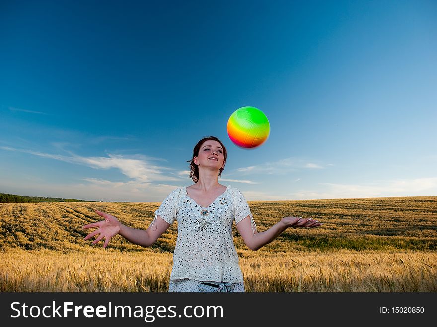 Young redhead woman at wheat field playing a ball. Young redhead woman at wheat field playing a ball