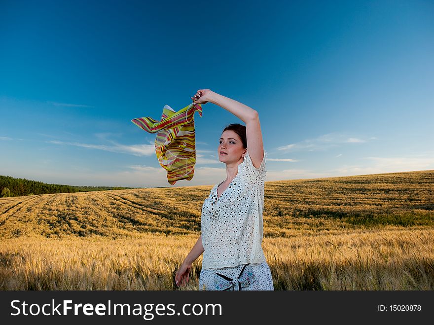 Young redhead woman at wheat field holding scarf. Young redhead woman at wheat field holding scarf