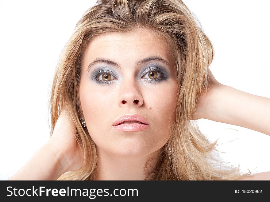 Closeup facial portrait of beautiful young woman with large grey eyes holding head with hands. Closeup facial portrait of beautiful young woman with large grey eyes holding head with hands