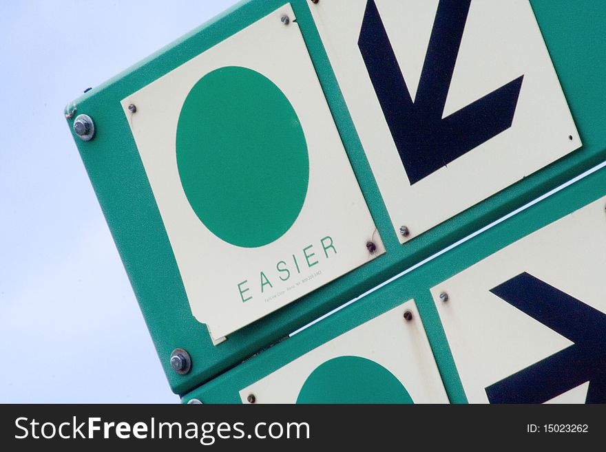 A trail sign at a Colorado ski resort points toward easy trails. A trail sign at a Colorado ski resort points toward easy trails.