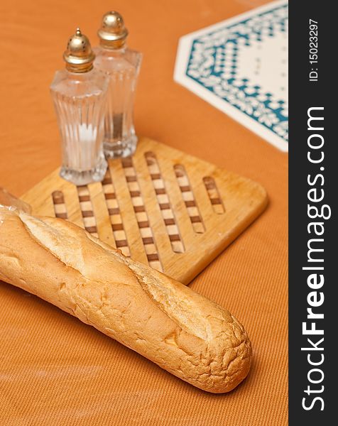 French loaf on a table with salt and pepper