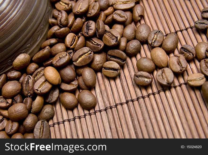 Roasted coffee beans near the ceramic bowl