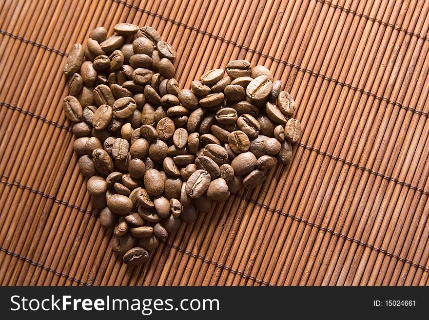Roasted coffee grains lying in the shape of the heart. Roasted coffee grains lying in the shape of the heart