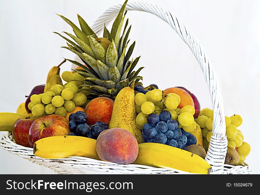 White fruit basket banana peach, pear, grapes