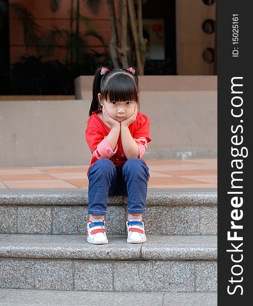 Asian Child Sitting On The Steps