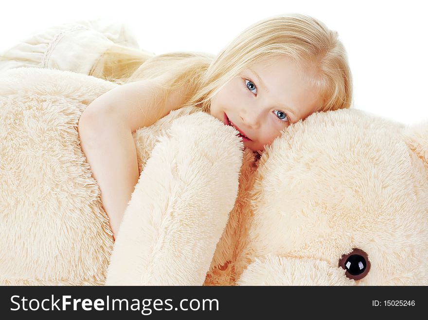 The beautiful girl embraces a plush bear