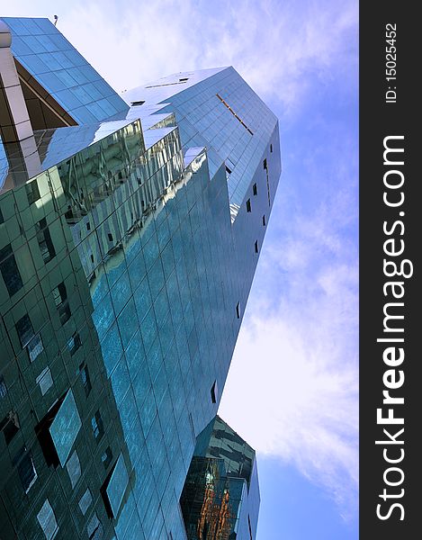 Modern building with glasses external wall, and background is blue sky and white cloud, means business or economy development concept